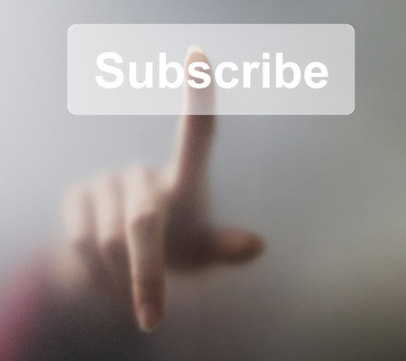 Woman pressing Subscribe button on grey background.の写真素材