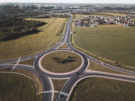 Top down aerial view of a traffic roundabout on a main road.