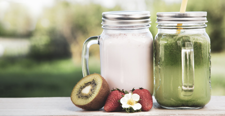 glass of detox smoothie and fruit on wooden table in the garden with fruit.の写真素材