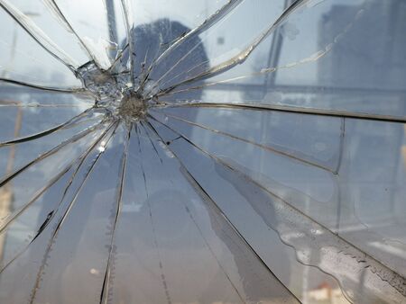 silhouette of a man behind broken glass