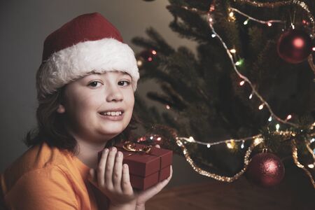 happy boy with christmas gift near Christmas treeの写真素材