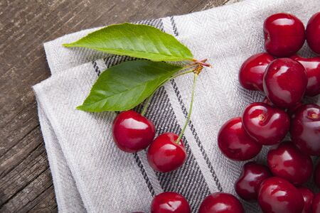 sweet cherry on fabric and wooden backgroundの写真素材