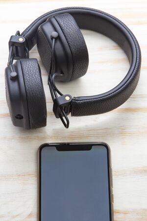 black headphones on smartphone music online concept, mockupの写真素材