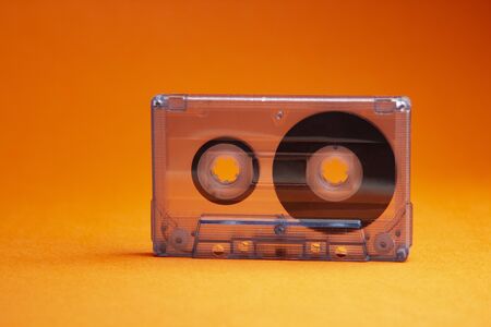Transparent audio cassette tape orange background. Front, view.の写真素材
