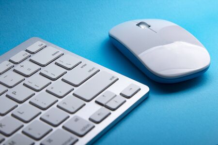 White Keyboard and Mouse on a blue tableの写真素材