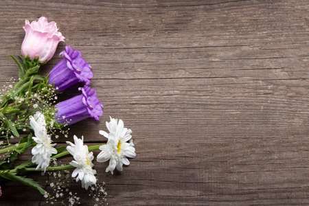 Wild flowers bouquet on wooden background.