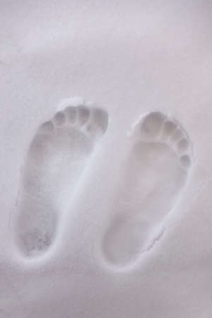two bare foot on the fresh white snowの写真素材