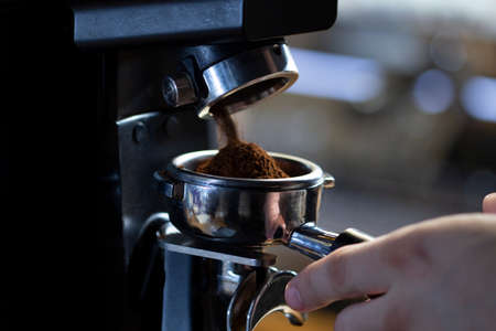 coffee grinder grinding coffee pouring into a portafilter