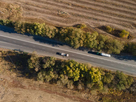 Aerial Top View of White Truck with Cargo Semi Trailer Moving on Road in Direction.の写真素材