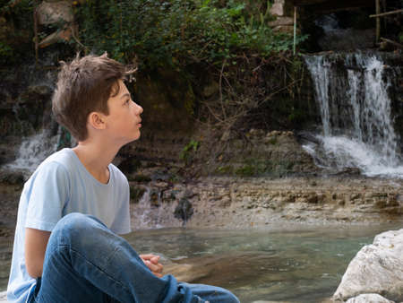 The teenager boy on mountain river beachの写真素材