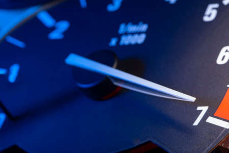 Car panel with tachometer engine with White arrow, Close up image of illuminated dashboard.