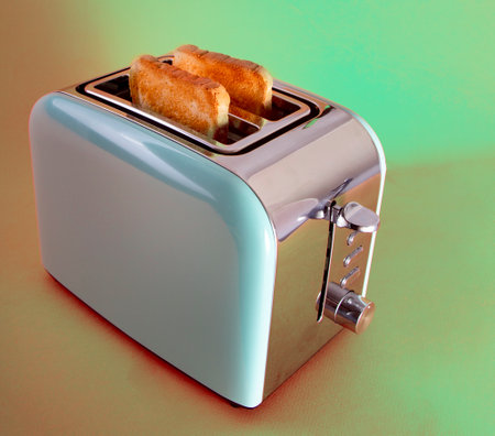 Slices of toast in Classic retro Styled Two Slot 2 Slice Toast Maker. Domestic and Home Electric Kitchen Appliancesの写真素材