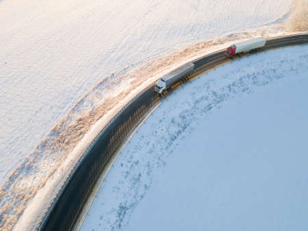 Lorry truck on the road surrounded by winter forest. Aerial viewの写真素材