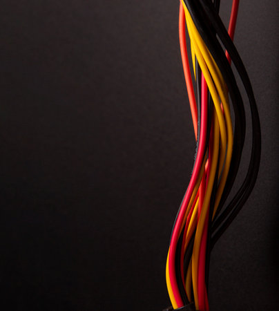 Bunch of colorful electrical telecommunication wire close-up. Telecommunication internet cable network and computer system. On black backgroundの写真素材