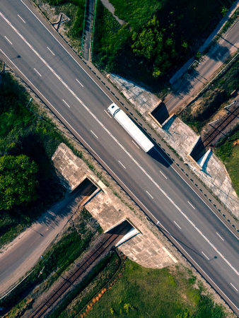 Aerial Top View of White Truck with Cargo Semi Trailer Moving on Road in Direction. Highway...
