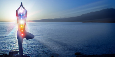 Silhouette of woman sits in a otus pose on beach sunset view, glowing seven all chakra. kundalini...