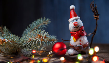 Christmas snowman decoration against the backdrop illumination and fir tree.の写真素材