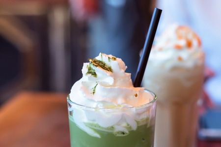 close up green tea matcha latte frappe with wipcreamの写真素材