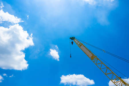 Mobile construction crane against sunlight and clear blue sky.の写真素材