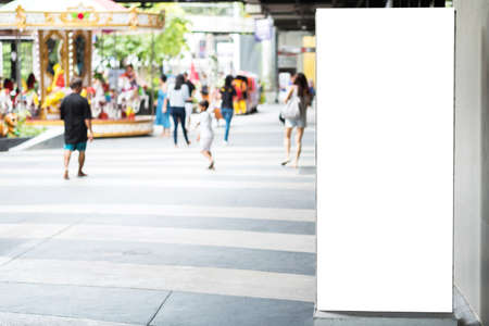 Blank advertising billboard with copy space for text, image and content at open air shopping mall with blurred background people walking and kids play ground. Mock up empty poster and banner display.の写真素材