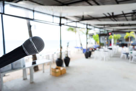 Close up Microphone on abstract blurred background of speech seminar, meeting, event in outdoor restaurant. Party concert on beach.の写真素材