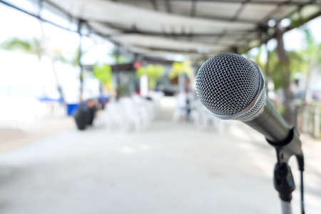 Close up Microphone on abstract blurred background of speech seminar, meeting, event in outdoor restaurant. Party concert on beach.の写真素材