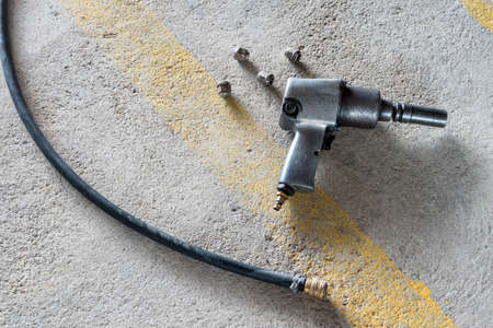 Air impact  wrench and bolts on the floor.の写真素材