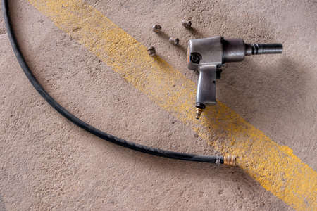 Air impact  wrench and bolts on the floor.の写真素材