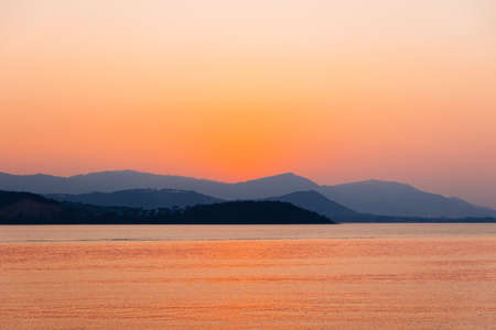 Beautiful sunrise and sunset with blue clouds over horizon clam blue sea and mountain background in...