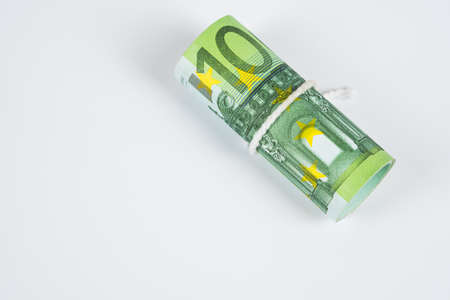 Roll of one hundred euro banknotes with white rope band isolated on white background.の写真素材
