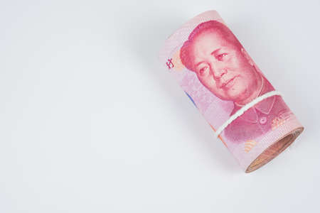 Roll of one hundred chinese yuan banknotes with white robe band isolated on white background.の写真素材
