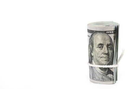 Roll of one hundred US dollar banknotes with white robe isolated on white background.の写真素材