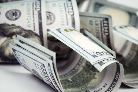 Several pile of new one hundred us dollar bills on table. Close up and selective focus on curved one...