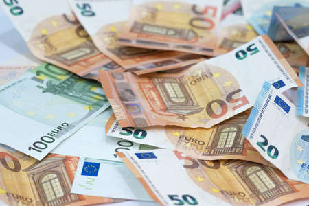 Euro money background from many euro banknotes in different value as twenty, fifty and on hundred bills placed on table.の写真素材