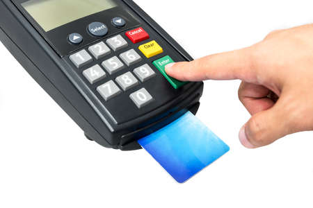 Man hand press enter button at credit card machine making payment for goods and service isolated on white background with clipping path.の写真素材