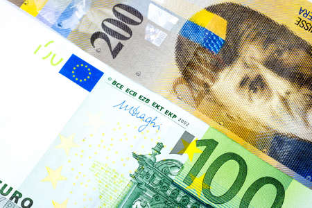 Close up one hundred Euro and two hundred swiss franc banknotes background in concept of business and economic relations, exchange trading between euro and swiss franc.の写真素材