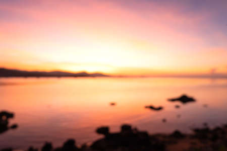 Beautiful blazing sunset landscape at black sea and mountain above orange sky with awesome sun golden reflection on calm sea as a background. Amazing summer sunset view on the beach.の写真素材