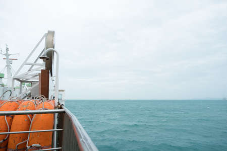 Side view of orange lifeboat steel fence and barrier to prevent passengers falling from boat. Small...
