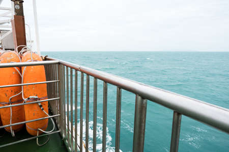 Side view of orange lifeboat steel fence and barrier to prevent passengers falling from boat. Small...