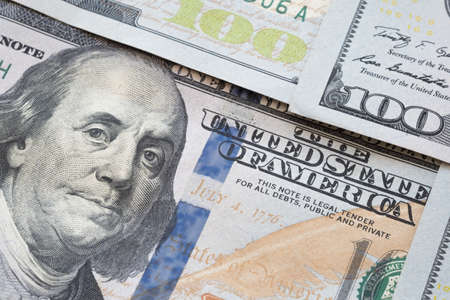 Pile of one hundred US dollar banknotes as money background. Stack of new American dollar bills on table in of financial and currency.の写真素材