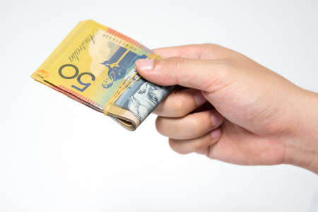 Close up  fifty Australia Dollar money bills in hand isolated on white background. Hand holding or...