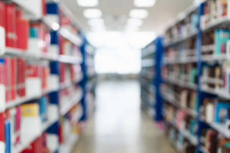 Blurred image of bookshelf in public library at school or university. Blurry image of books on shelf in bookstore. Learning and education background concept.の写真素材