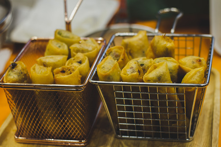 Thai Spring Roll in colander square steel sieve on wooden tray.の写真素材
