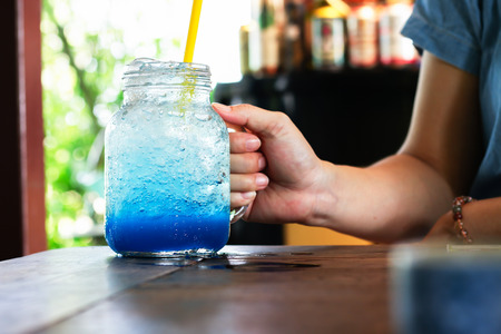 Woman hand holding blue soda glassの写真素材
