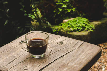 Hot coffee mugs on a wooden table in the gardenの写真素材