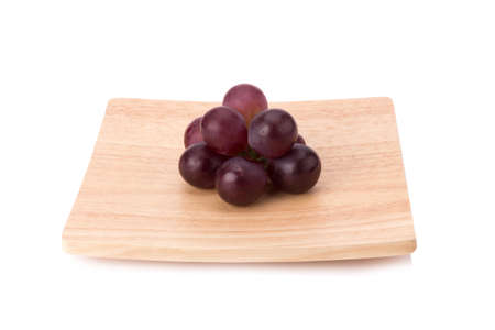 Ripe red grape with leaves isolated on white.の写真素材