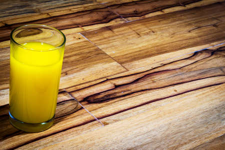 glass of orange juice on wooden table.の写真素材