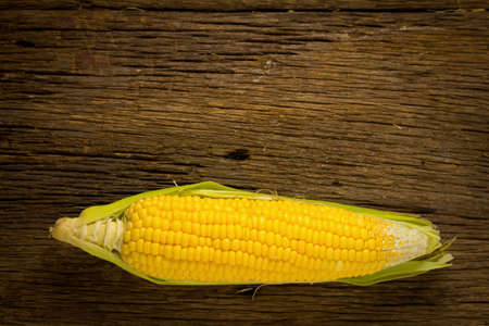 corn fresh on old wood and flower Plumeria. morning sun. beautiful corn. view top.
