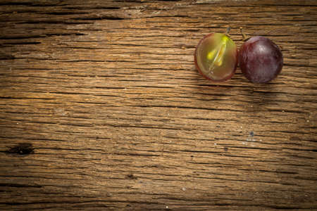 red grapes. slice. half. on wooden table.の写真素材