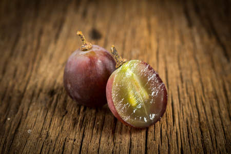 red grapes. slice. half. on wooden table.の写真素材